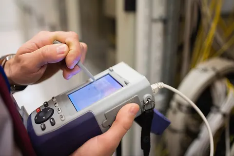 Handheld cable tester connected to a network cable
